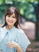 A woman in a blue shirt smiles at the camera.